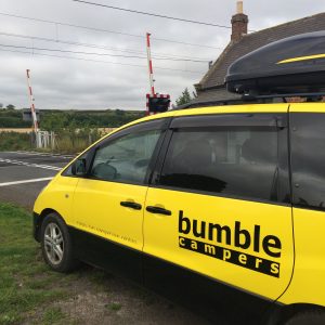 Bumble camper beside a level crossing