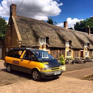 Bumble camper beside a thatched cottage